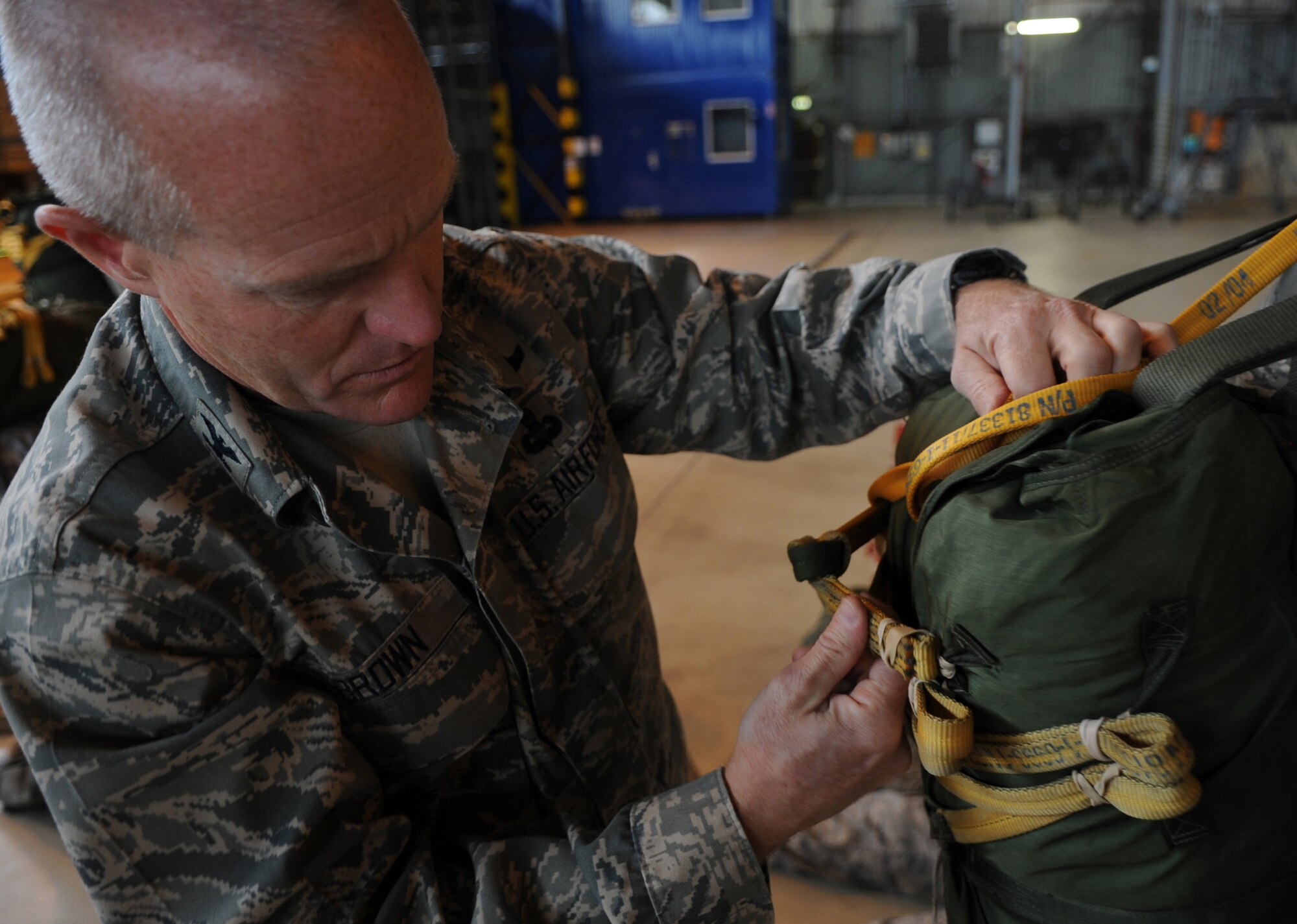 U.S. Air Force Col. Timothy Brown, 435th Contingency Response Group commander, inspects a parachute prior to a static line jump from a C-130J as part of the NATO jump week, Ramstein Air Base, Germany, June 15, 2010. Five NATO countries participated in the annual event to support one of United States Air Forces in Europe's top priorities; building partnerships. (U.S. Air Force photo by Airman 1st Class Caleb Pierce)