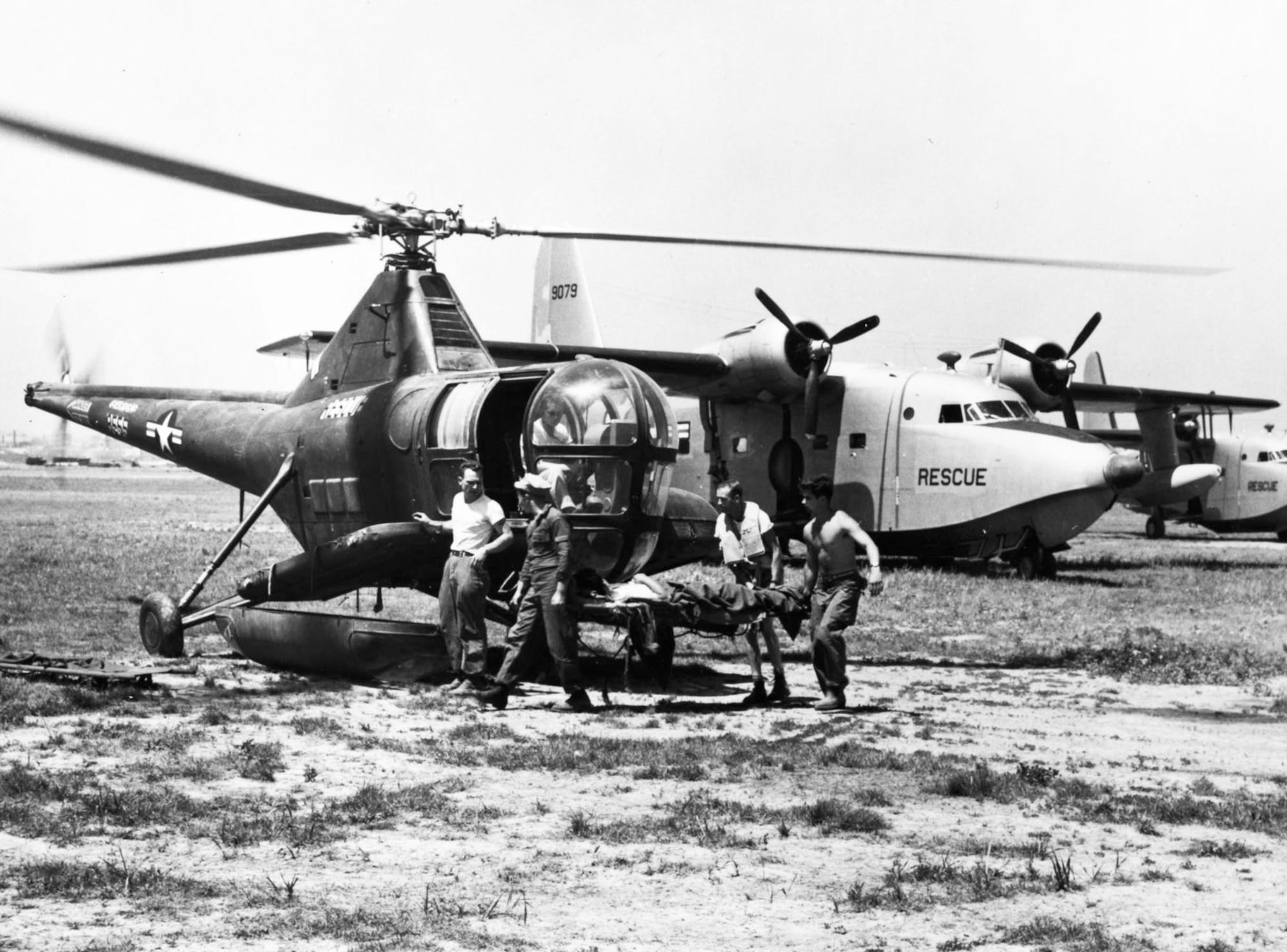 Helicopters and seaplanes worked together. Here, Airmen transfer a patient from the SA-16 Albatross amphibian in the background to an H-5G helicopter. (U.S. Air Force photo)