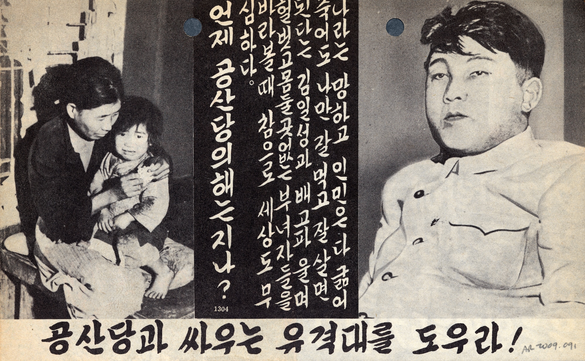 Written in Korean, this leaflet contrasted communist leaders’ luxury with the poverty of the average North Korean citizen. The front shows poor Koreans watching an extravagant party from outside a guarded building. The back (shown here) shows a poorly-clothed and starving mother and child compared to the well-fed leader of North Korea, Kim Il Sung. (U.S. Air Force photo)