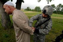 Staff Sgt. Christian Bennett, right, 115th Security Forces Squadron Fire Team Leader, detains an insurgent, played by Senior Master Sgt. Todd Weinberger, at Volk Field Combat Readiness Training Center, Wis., June 14, 2010. Security Forces search a mock village for a person of interest, while training how to preserving the peace in a hostile environment. (U.S. Air Force photo by Tech Sgt. Ashley Bell)