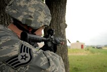 Staff Sgt. Christian Bennett, 115th Security Forces Squadron Fire Team Leader, fires on insurgents during a training scenario at Volk Field Combat Readiness Training Center, Wis., June 14, 2010. Security Forces search a mock village for a person of interest, while training how to preserving the peace in a hostile environment. (U.S. Air Force photo by Tech Sgt. Ashley Bell)