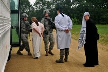 Members of the 115th Fighter Wing Security Forces Squadron, stand guard and lead insurgents onto a secure bus, during a Security Forces counter insurgency (COIN) exercise, at Volk Field Combat Readiness Training Center, Wis., June 14, 2010. Members of Services Flight and Security Forces Squadron were assigned houses, wore traditional Middle Eastern garb, and were instructed to engage security forces during their patrol through the simulated village. (U.S. Air Force photo by Staff Sgt. Christen Bloomfield)