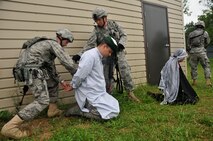 Members of the 115th Fighter Wing Security Forces Squadron stand guard and hand cuff insurgents, they had fired upon them during a Security Forces counter insurgency (COIN) exercise, at Volk Field Combat Readiness Training Center, June 14, 2010. Members of Services Flight and Security Forces Squadron were assigned houses, wore traditional Middle Eastern garb, and were instructed to engage security forces during their patrol through the simulated village. (U.S. Air Force photo by Staff Sgt. Christen Bloomfield)