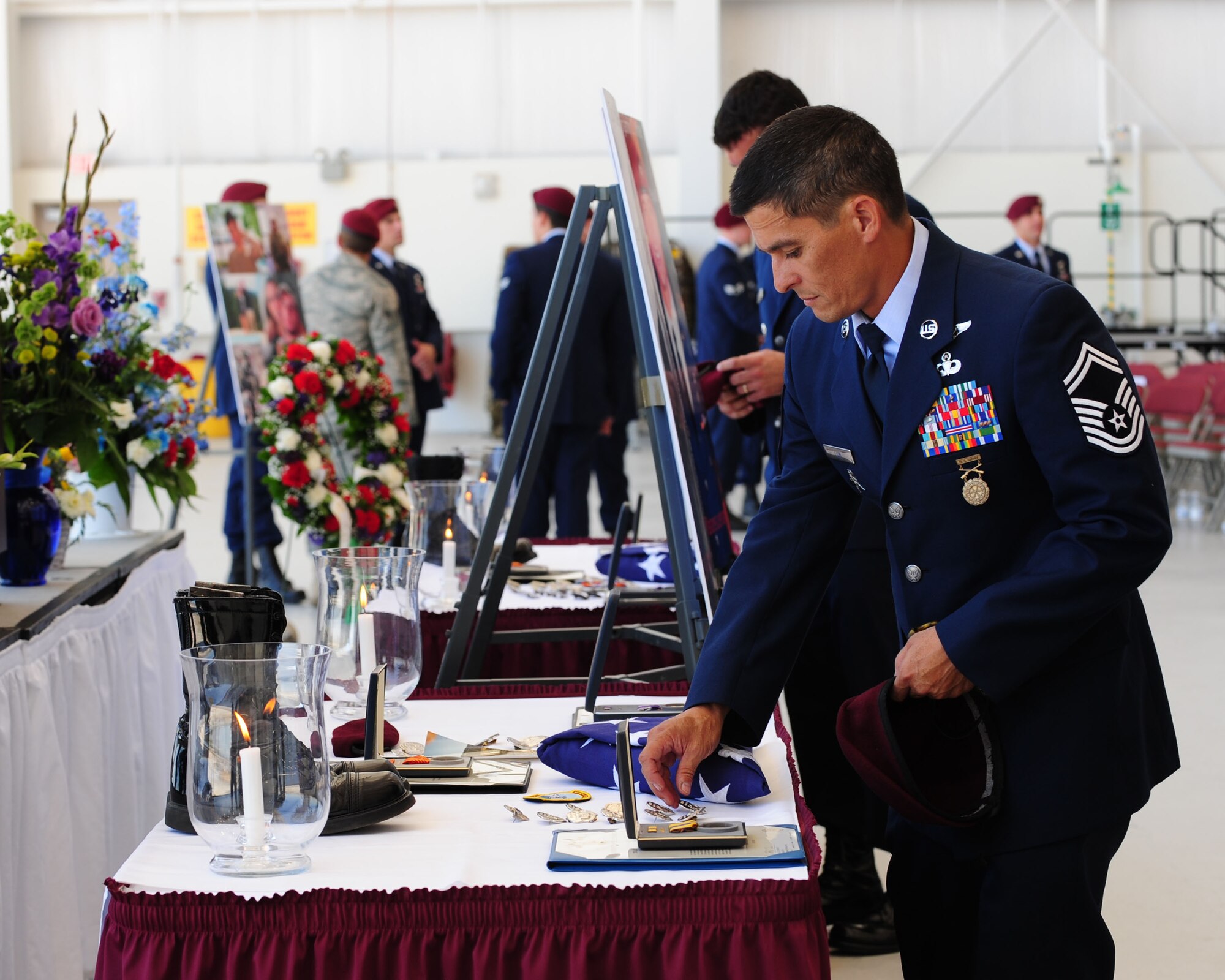 A pararescueman assigned to the 48th Rescue Squadron pays his last respects to Tech. Sgt. Michael Flores and Senior Airman Benjamin White after a memorial service held in their honor here June 17. Sergeant Flores and Airman White were among the four Airmen killed in a helicopter crash on June 9 in southeastern Afghanistan while on deployment in support of Operation Enduring Freedom. (U.S. Air Force photo/Airman 1st Class Jerilyn Quintanilla)
