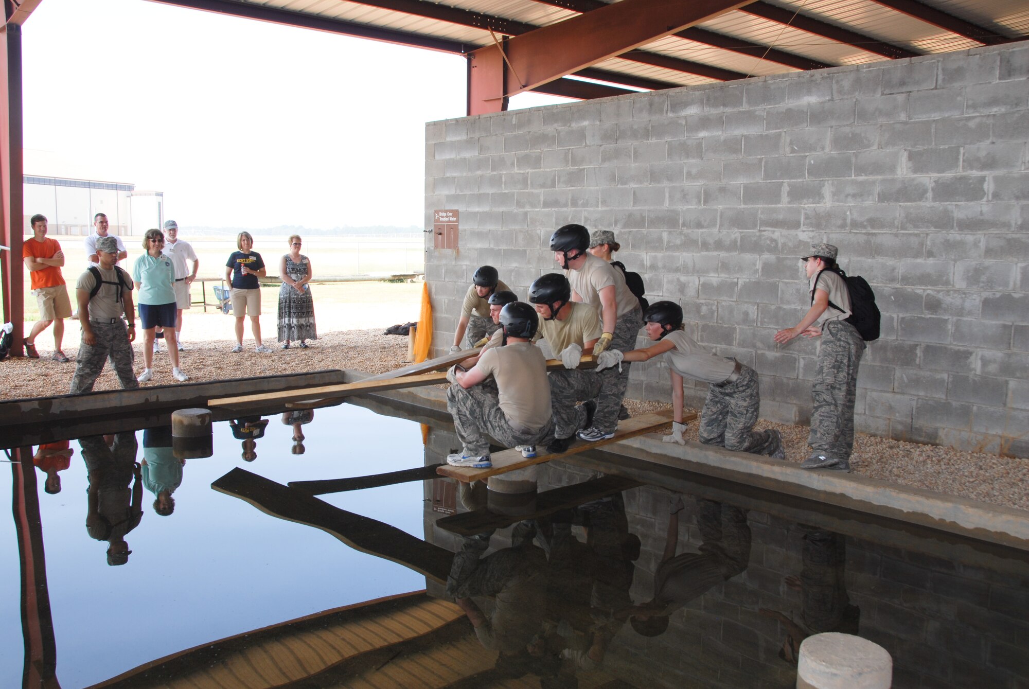 Representatives of 25 colleges and universities visited Maxwell last week to see first-hand Air Force ROTC programs in action and learn how their schools can support the corps. Visitors with the Distinguished Educators program watch ROTC cadets negotiate an obstacle at the Leadership Reaction Course. (U.S. Air Force/Stephen Hynes)