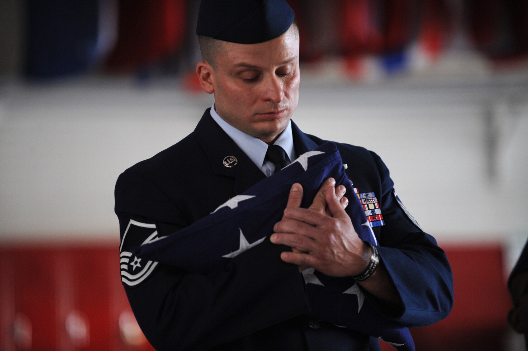 NELLIS AIR FORCE BASE, Nev. -- Master Sgt. Kristopher Angone, 66th Rescue Squadron holds an American Flag in remembrance of his fallen comrades during a memorial ceremony at Nellis Air Force Base, Nev. June 18 to honor 1st Lt. Joel Gentz, 25, a combat rescue officer assigned to the 58th Rescue Squadron; and Staff Sgt. David Smith, 26, a helicopter flight engineer assigned to the 66th Rescue Squadron. The two were among four Airmen killed and three wounded when an HH-60G Pave Hawk helicopter crashed during a medevac mission in southeastern Afghanistan June 9.  (U.S. Air Force photo by Master Sgt. Kevin Gruenwald) 


