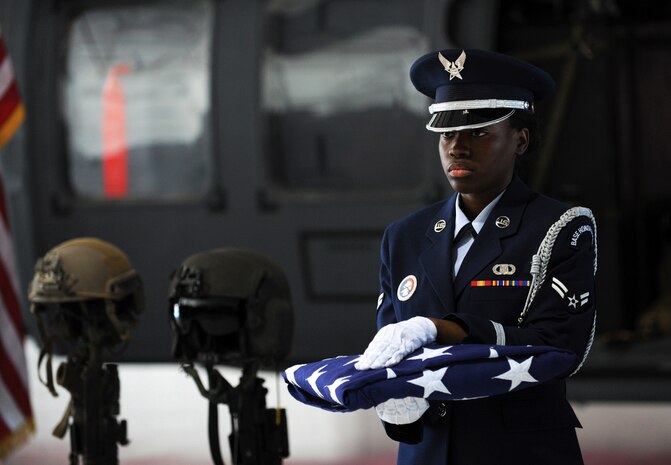 NELLIS AIR FORCE BASE, Nev. -- Nellis honor guard member Airman 1st Class Shenika Lattimore, folds the flag prior to presentation during a memorial ceremony at Nellis Air Force Base, Nev. June 18 to pay final respects to 1st Lt. Joel Gentz, 25, a combat rescue officer assigned to the 58th Rescue Squadron; and Staff Sgt. David Smith, 26, a helicopter flight engineer assigned to the 66th Rescue Squadron. The two were among four Airmen killed and three wounded when an HH-60G Pave Hawk helicopter crashed during a medevac mission in southeastern Afghanistan June 9. (U.S. Air Force photo by Master Sgt. Kevin Gruenwald) released



