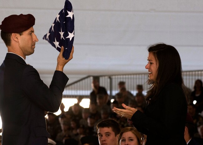 NELLIS AIR FORCE BASE, Nev. -- Lt. Col. Andrew Reisenweber, 58th Rescue Squadron Commander, hands a funeral flag to Mrs. Kathryn Gentz, wife of 1st Lt. Joel Gentz, 25, a combat rescue officer assigned to the 58th Rescue Squadron during a memorial ceremony at Nellis Air Force Base June 18. (U.S. Air Force Photo / Airman 1st Class Jamie Nicley)