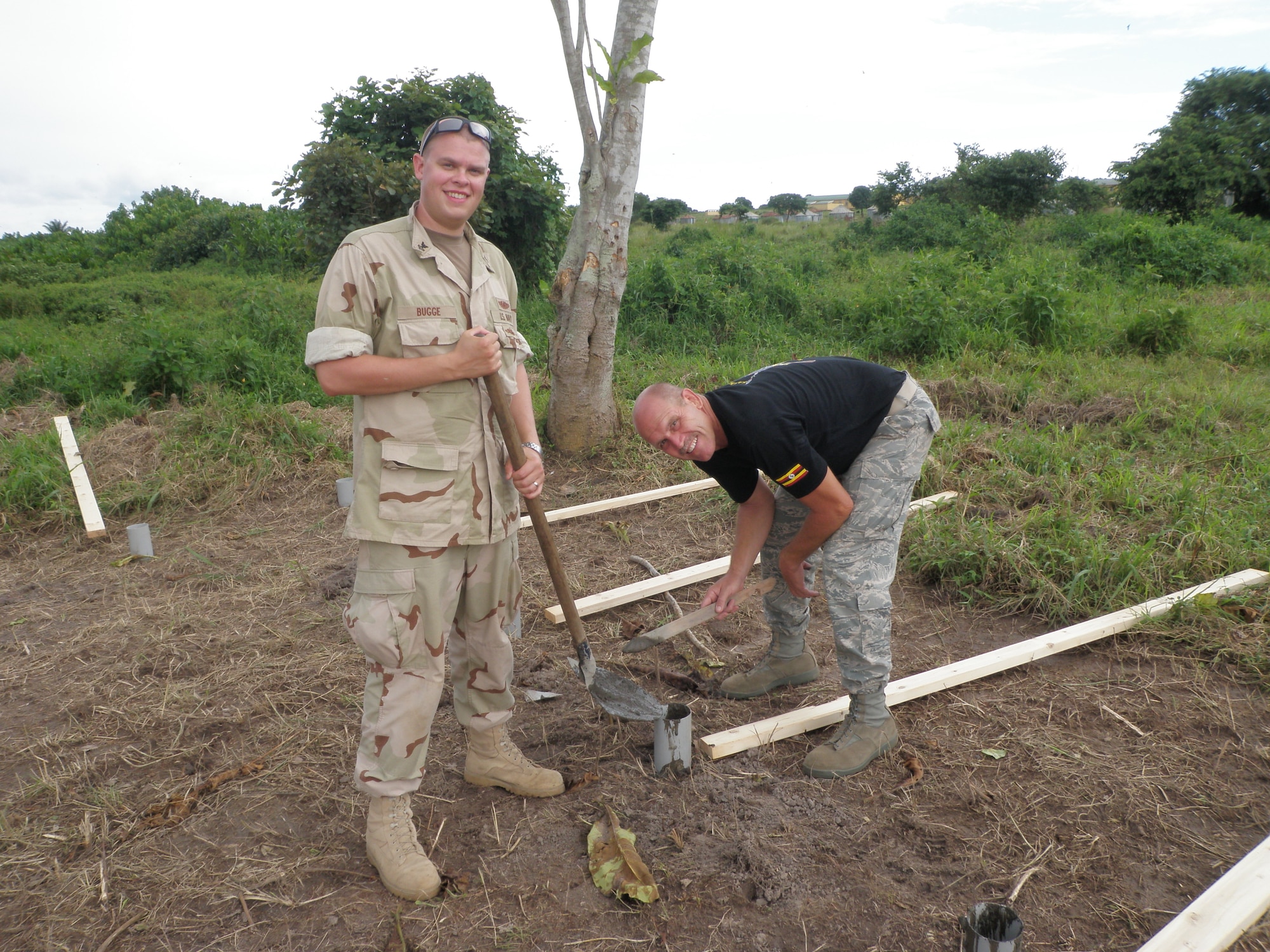 Petty Officer Brian Bugge and MSgt David Zibell prepare posts for a mock village in Uganda used for close quarter’s combat training.