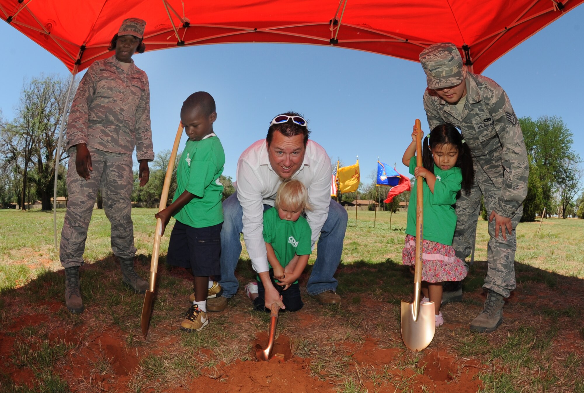 Quran Mighty (left), her mother, Staff Sgt. Racquel Farquhason, 27th Special Operations Comptroller Squadron, Kiara Morgan (middle), her father, Tres Morgan, and Zoe Jones, with her father, Staff Sgt. Gregory Jones, 373rd Training Squadron Det 17, begin the groundbreaking of the new Child Development Center at Cannon Air Force Base, N.M., June 18. The new facility will incorporate a new standardized design for Child Development Centers and will include natural outdoor classrooms in the outdoor play areas. (U.S. Air Force photo by Airman 1st Class Maynelinne De La Cruz) 