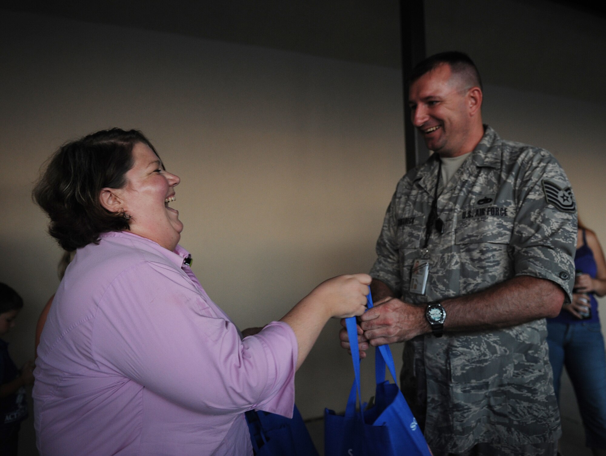 MOODY AIR FORCE BASE, Ga. -- Debra O’Brien, Moody Base Exchange store manager, welcomes home Tech. Sgt. Christopher Kuhaneck, 23rd Equipment Maintenance Squadron structural maintenance, with a bag of goods from AAFES here June 17. The other members returning from a deployment to Iraq also received a goody bag. (U.S. Air Force photo by Staff Sgt. Gina Chiaverotti-Paige/RELEASED)