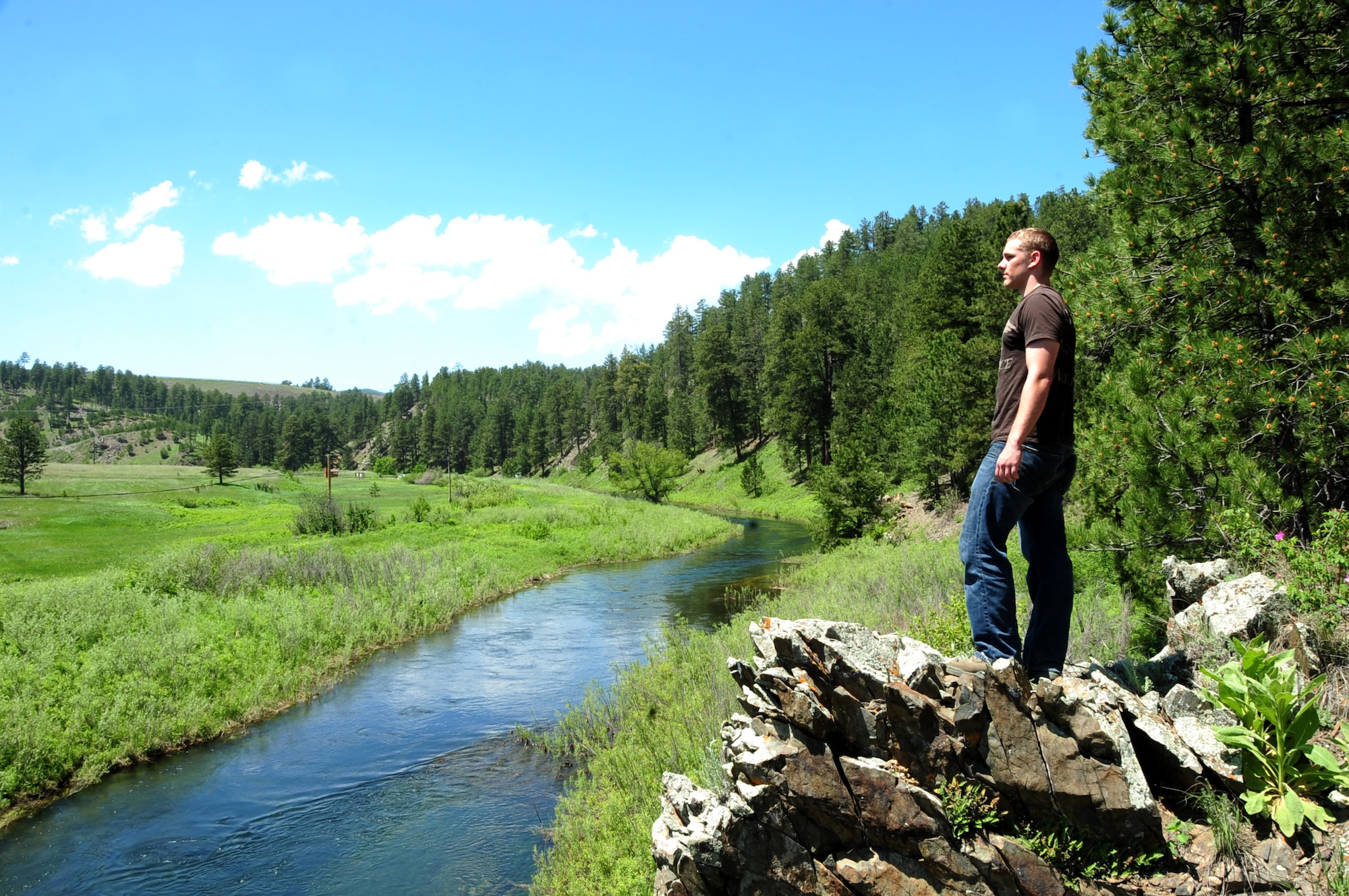 ELLSWORTH AIR FORCE BASE, S.D. -- Airman 1st Class Mitchell Carrell, 28th Civil Engineer Squadron firefighter, takes a break after climbing an out-crop of rocks in the summer heat at Rapid Creek Trail Head, Rapid City, S.D., 16 June.  To avoid overheating and heat stress, drink plenty of water and take breaks periodically when out in the summer heat. (U.S. Air Force photo/Airman 1st Class Anthony Sanchelli)
