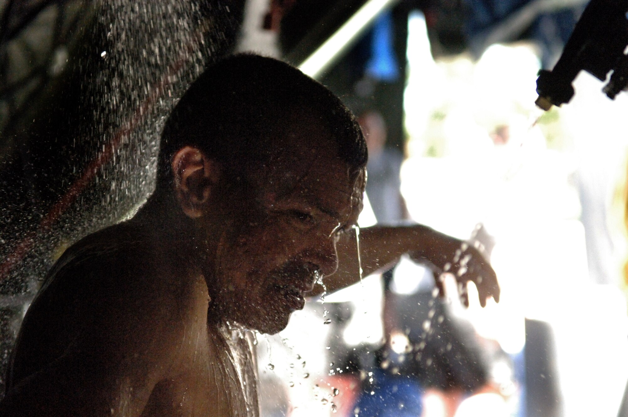 ELLSWORTH AIR FORCE BASE, S.D. -- Private Jose Benavides, Army National Guard, 704th Chemical Company chemical biological radiological and nuclear specialist, processes through a simulated decontamination tent during the 2010 Golden Coyote exercise at Camp Lancer, Ellsworth Air Force Base, S.D., June 18.  The shower is a mixture of water, chemicals and an abrasive brush designed to remove any contamination from a CBRNE casualty. (U.S. Air Force photo/Airman 1st Class Jarad Denton)
