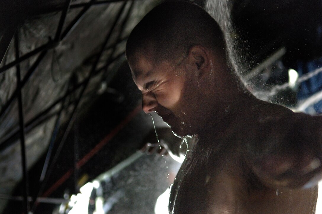 ELLSWORTH AIR FORCE BASE, S.D. -- An Army National Guard soldier from the 704th Chemical Company chemical biological radiological and nuclear specialist, processes through a simulated decontamination tent during the 2010 Golden Coyote exercise at Camp Lancer, Ellsworth Air Force Base, S.D., June 18.  The shower is regulated at a certain temperature to reduce the shock put on a casualty's system. (U.S. Air Force photo/Airman 1st Class Jarad Denton)