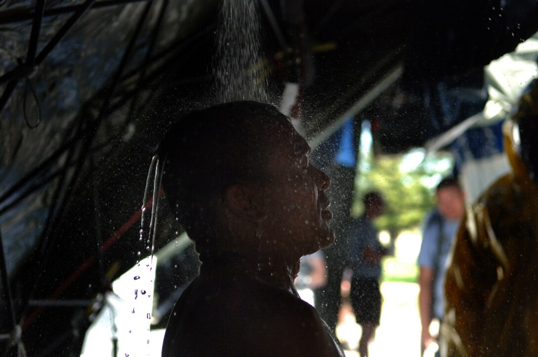 ELLSWORTH AIR FORCE BASE, S.D. -- Private Jose Benavides, Army National Guard, 704th Chemical Company chemical biological radiological and nuclear specialist, processes through a simulated decontamination tent during the 2010 Golden Coyote exercise at Camp Lancer, Ellsworth Air Force Base, S.D., June 18.  The shower is meant to wash away any contamination which may be picked up during a CBRNE attack. (U.S. Air Force photo/Airman 1st Class Jarad Denton)