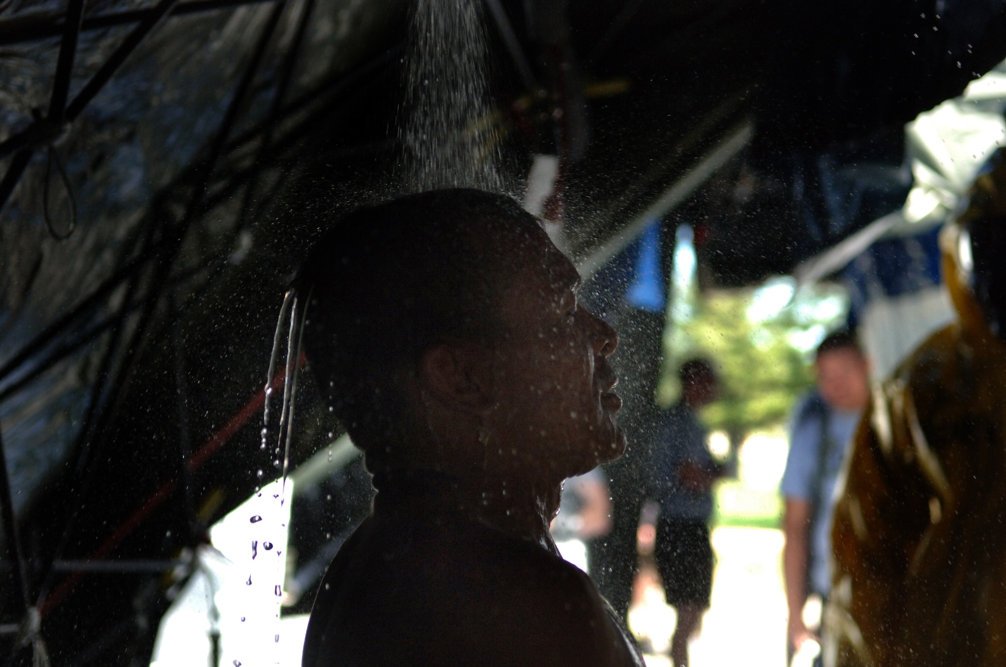 ELLSWORTH AIR FORCE BASE, S.D. -- Private Jose Benavides, Army National Guard, 704th Chemical Company chemical biological radiological and nuclear specialist, processes through a simulated decontamination tent during the 2010 Golden Coyote exercise at Camp Lancer, Ellsworth Air Force Base, S.D., June 18.  The shower is meant to wash away any contamination which may be picked up during a CBRNE attack. (U.S. Air Force photo/Airman 1st Class Jarad Denton)