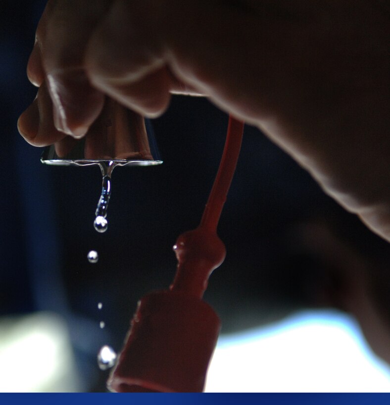 ELLSWORTH AIR FORCE BASE, S.D. -- Staff Sgt. James Kinzer, Army National Guard, 704th Chemical Company additional duty safety representative, adjust a shower head to stop a leak in the decontamination tent, during the 2010 Golden Coyote exercise at Camp Lancer, Ellsworth Air Force Base, S.D., June 18. "The main focus here is to take care of civilian casualties," said Sergeant Kinzer. (U.S. Air Force photo/Airman 1st Class Jarad Denton)