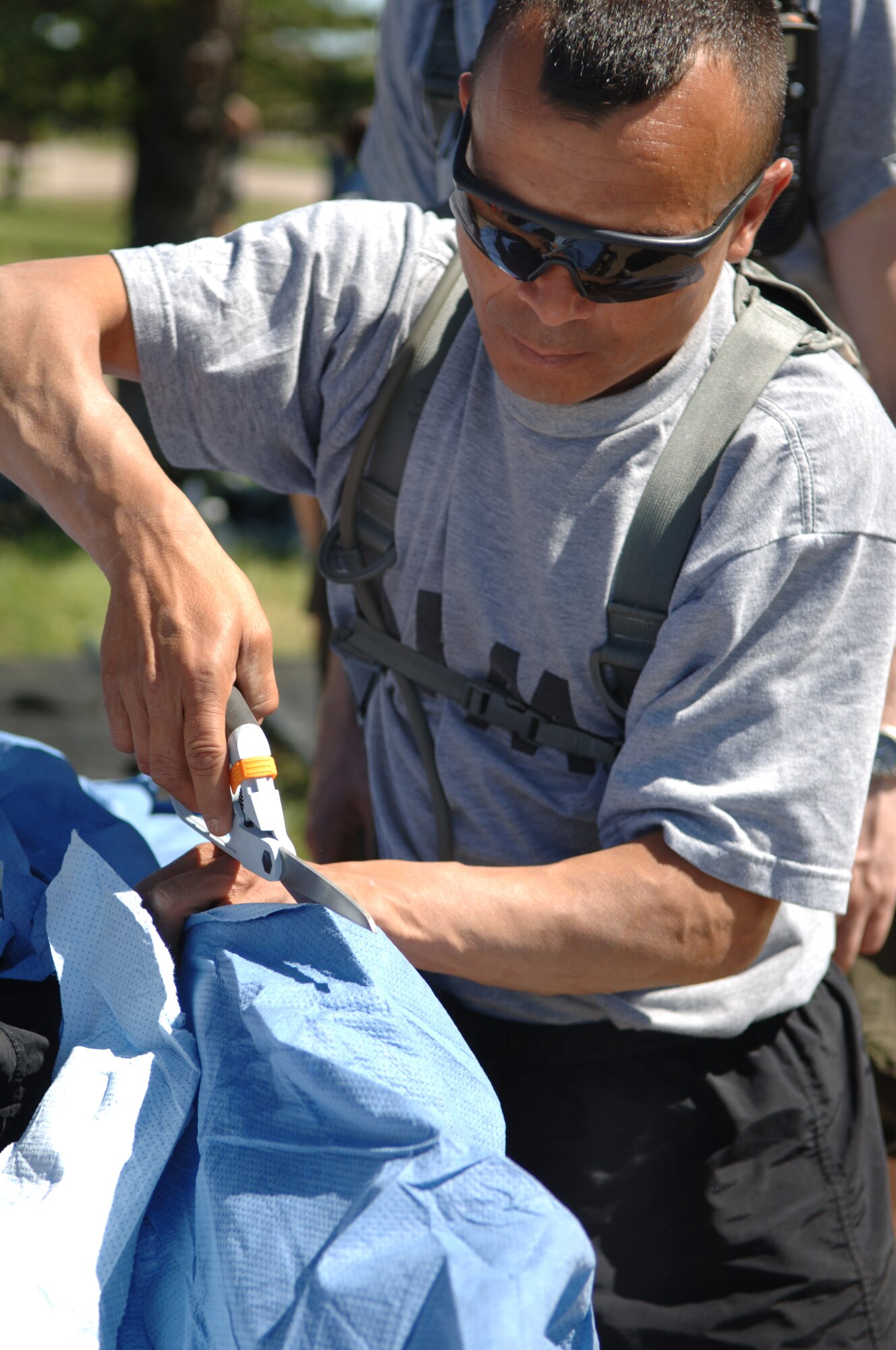 ELLSWORTH AIR FORCE BASE, S.D. -- Private Jose Benavides, Army National Guard, 704th Chemical Company chemical biological radiological and nuclear specialist, cuts a protective suit off of a simulated casualty during the 2010 Golden Coyote exercise at Camp Lancer, Ellsworth Air Force Base, S.D., June 18.  The protective suit is removed to ascertain any physical injures sustained during an attack. (U.S. Air Force photo/Airman 1st Class Jarad Denton)