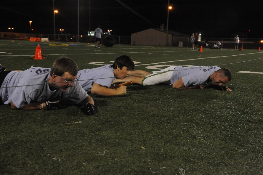 DYESS AIR FORCE BASE, Texas—(left to right) Danny Haddox, Arnaldo Gjocaj and Staff Sgt. Matthew Johnston, 7th Civil Engineer Squadron, low crawl June 18 as part of an obstacle course challenge sponsored by the Dyess Fitness Center here. Fit camp members and other Airmen participated on the course, which consisted of challenges such as push-ups, low crawls and tire flipping. (U.S Air Force photo/ Airman 1st Class Shannon Hall)