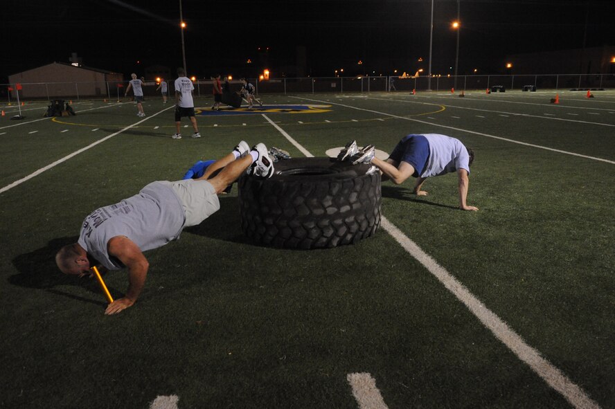 DYESS AIR FORCE BASE, Texas—Members from Dyess Fit Camp do push-ups June 18 as part of an obstacle course challenge sponsored by the Dyess Fitness Center here. Fit camp members and other Airmen participated on the course, which consisted of challenges such as push-ups, low crawls and tire flipping. (U.S Air Force photo/ Airman 1st Class Shannon Hall)