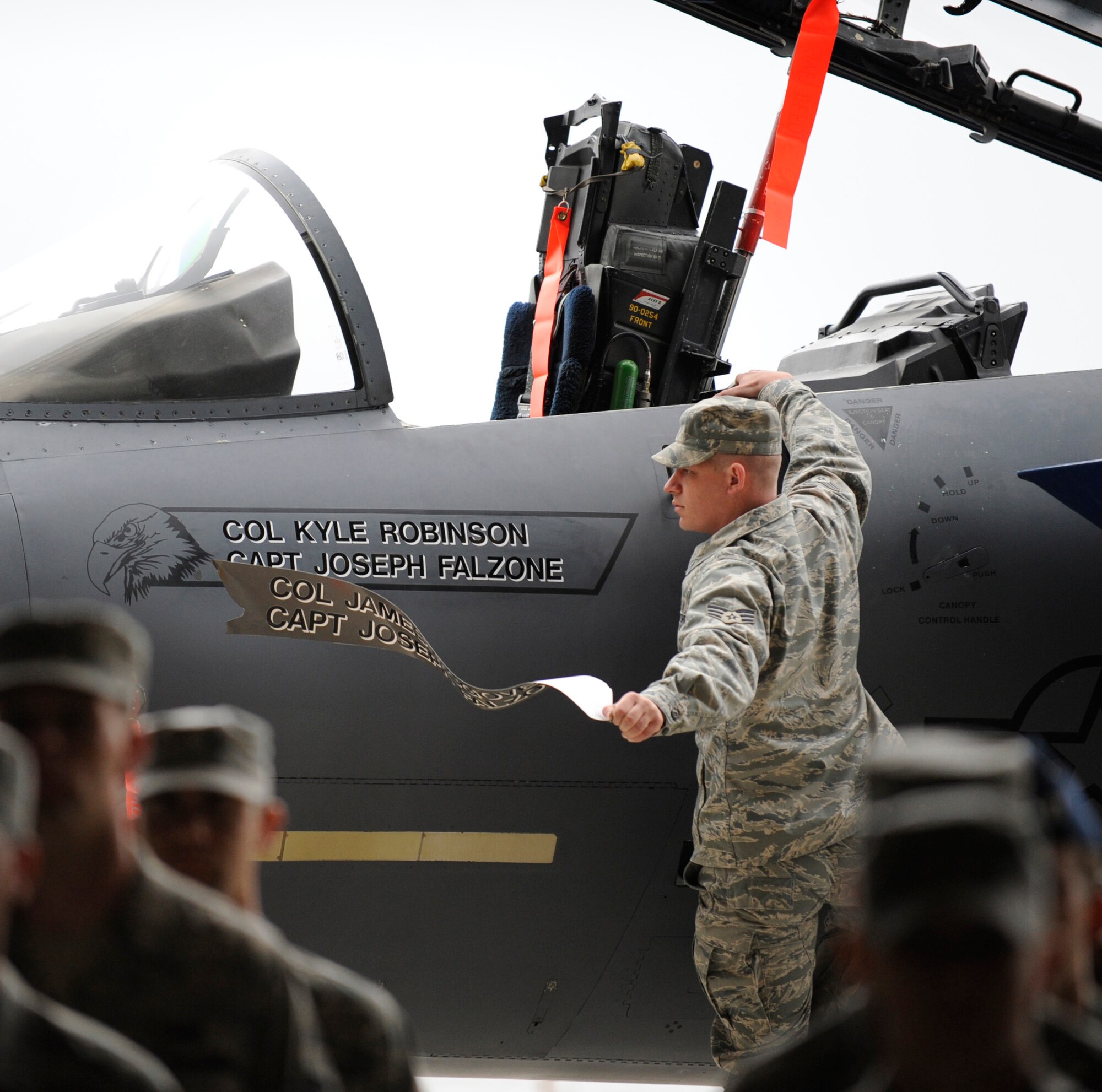 MOUNTAIN HOME AIR FORCE BASE, Idaho -- SrA Benjamin Gibson, 366th Aircraft Maintenance crew chief, unveils the new flagship for Gunfighter 3 at a Change of Command Ceremony in hangar 1331 June 16. Col. Kyle Robinson assumed command of the 366th Operations Group. (U.S. Air Force photo by Airman 1st Class Renishia Richardson)