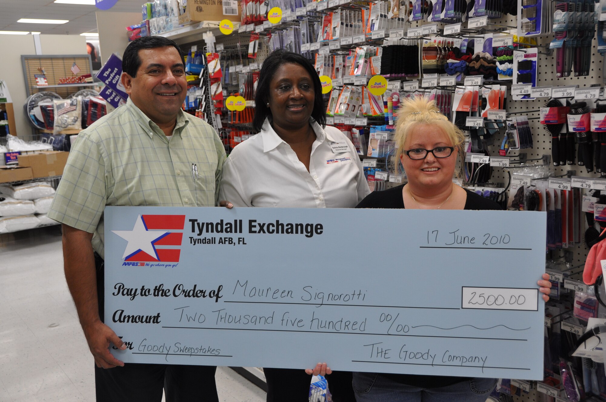 Maureen Signorotti, was presented a $2,500 check for her participation in the nation-wide Goody Sweepstakes June 17 at the Tyndall AFB Base. Sulola Kimbrough, Goody representative and Al Fuentes, Tyndall Air Force Base Army and Air Force Exchange Service general manager, presented her the check.  Mrs. Signorotti is the wife of Staff Sgt. Brandon Signorotti, 325th Aircraft Maintenance Squadron F-15 weapons load crew team chief.