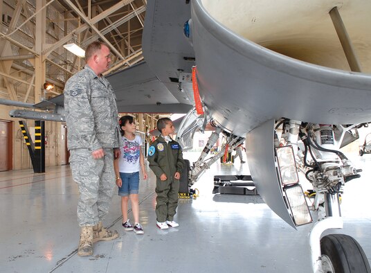Staff Sgt. Jerry Tucker, 309th Aircraft Maintenance Unit crew chief, gives Zuriah Acosta and Isaiah Acosta, pilot-for-a-day, a tour of an F-16 Fighting Falcon June 11 in Hangar 914. (Photo by Airman 1st Class Ronifel Yasay)