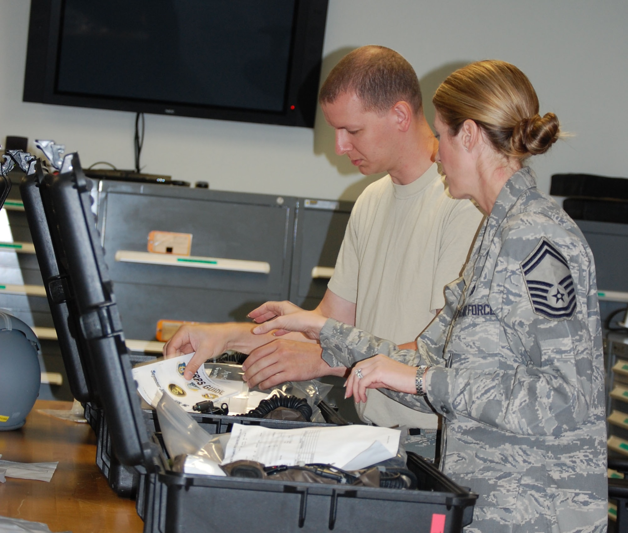 Senior Master Sgt. Dana Bates (right) prepares for class in the aircrew flight equipment shop here at the 916th Air Refueling Wing. (USAF by Ms. Donna Lea, 916ARW/PA)