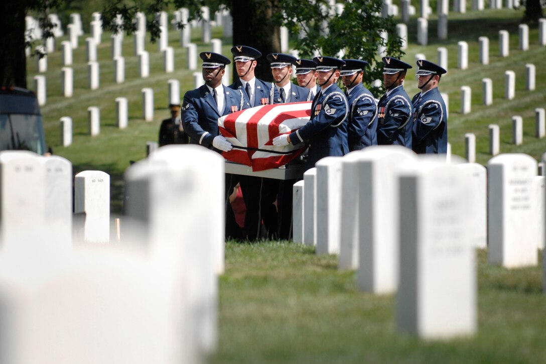 An Air Force honor guard carries a casket holding unidentified remains during a burial service at Arlington National Cemetery on June 17.  The ceremony honored 14 Airmen who were killed in March 1972 when their aircraft was shot down over southern Laos.  (DoD photo/Army Sgt. 1st Class Michael J. Carden)