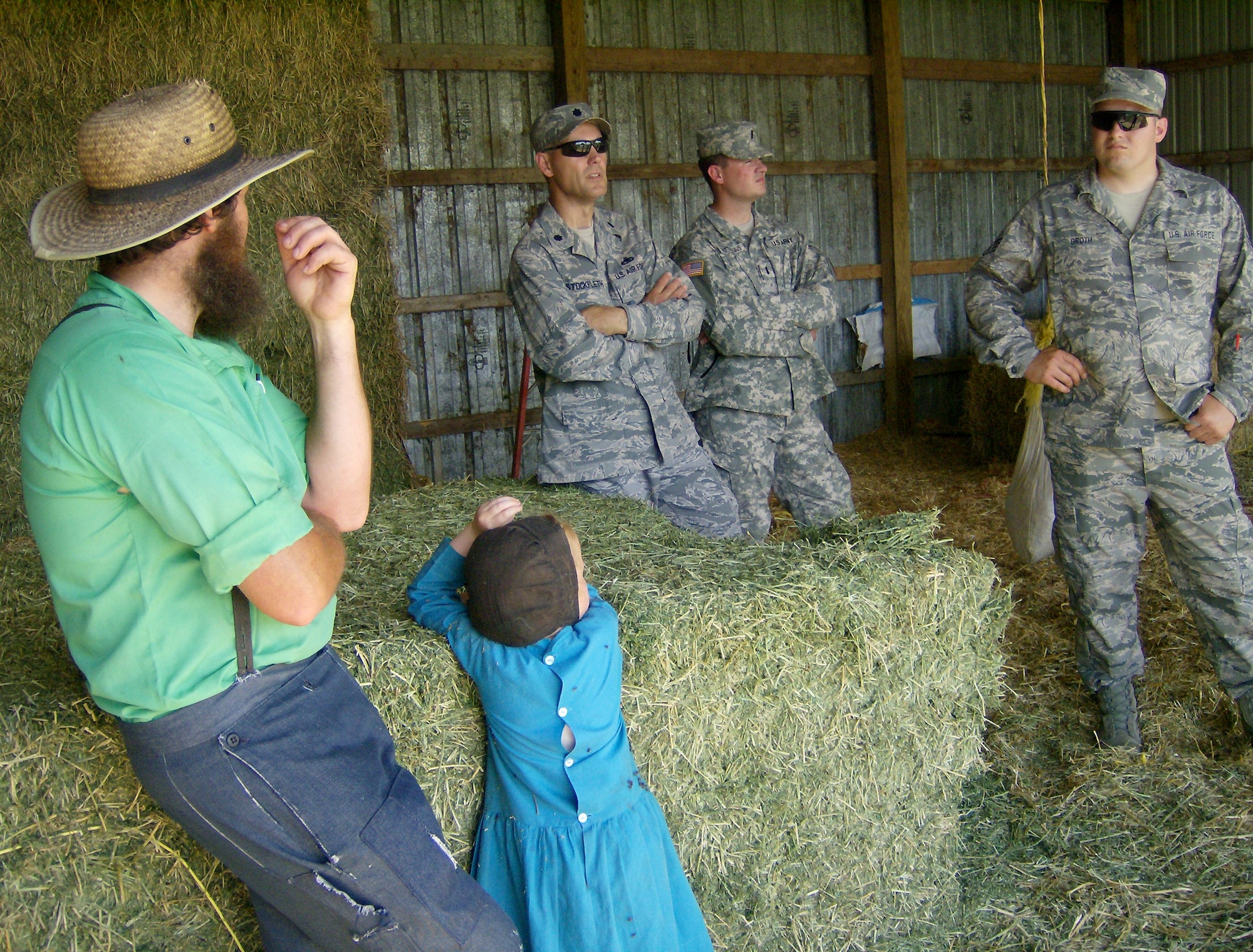 With his daughter watching, a northeast Iowa Amish farmer discusses his operation with Lt. Col. Neil Stockfleth, Officer-in-Charge of the Iowa National Guard's 734th Agri-Business Development Team Ag Section, and from left, Ag Section members 1st Lt. Scott Rottinghaus and Staff Sgt. Ben Groth.