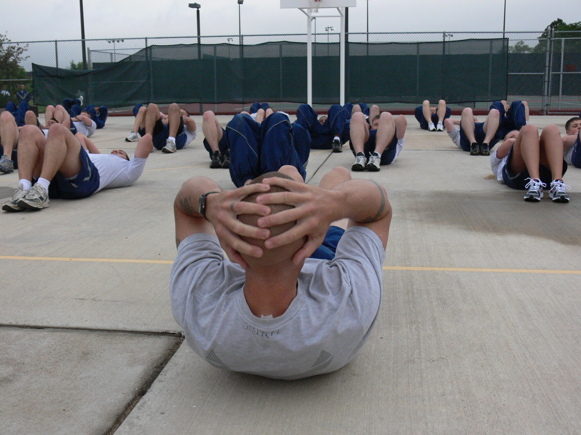 Master Sgt. Frank Green, 21st Security Forces Squadron, leads squadron physical fitness training June 14 on Peterson Air Force Base. The 21st SFS switched from 12-hour shifts to eight-hour shifts in April. The move is part of the new integrated defense plan, which changes how the squadron polices the base and how it uses its resources. The new eight-hour shifts allowed the squadron to have unit PT once again. (U.S. Air Force photo/Monica Mendoza)