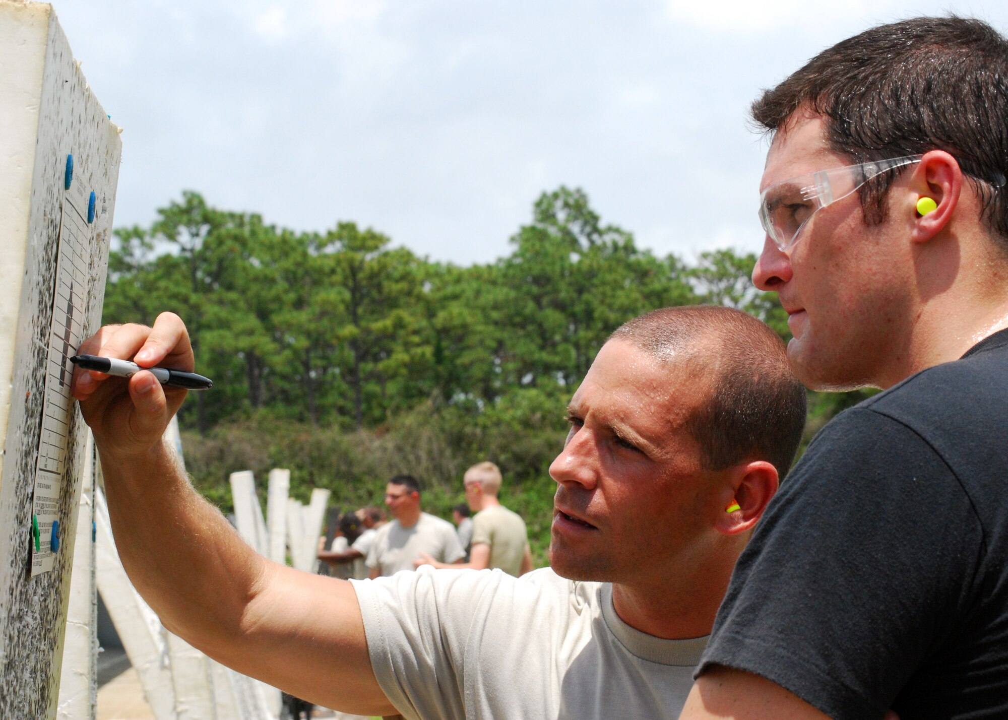 Senior Airman Ian Knight, 919th Security Forces Squadron, shows Senior Airman Andrew Gard, 919th Civil Engineer Squadron, where he needs to adjust his sights on his M-16A2 at the Hurlburt Field firing range June 5. The Duke Field reservist engineers must qualify annually to meet deployment readiness requirements. (U.S. Air Force photo/Tech. Sgt. Cheryl Foster)