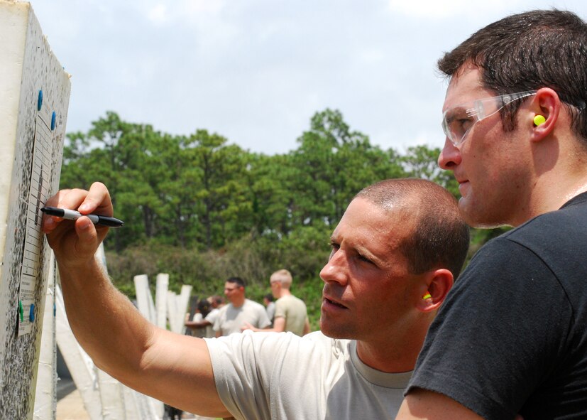 Senior Airman Ian Knight, 919th Security Forces Squadron, shows Senior Airman Andrew Gard, 919th Civil Engineer Squadron, where he needs to adjust his sights on his M-16A2 at the Hurlburt Field firing range June 5. The Duke Field reservist engineers must qualify annually to meet deployment readiness requirements. (U.S. Air Force photo/Tech. Sgt. Cheryl Foster)