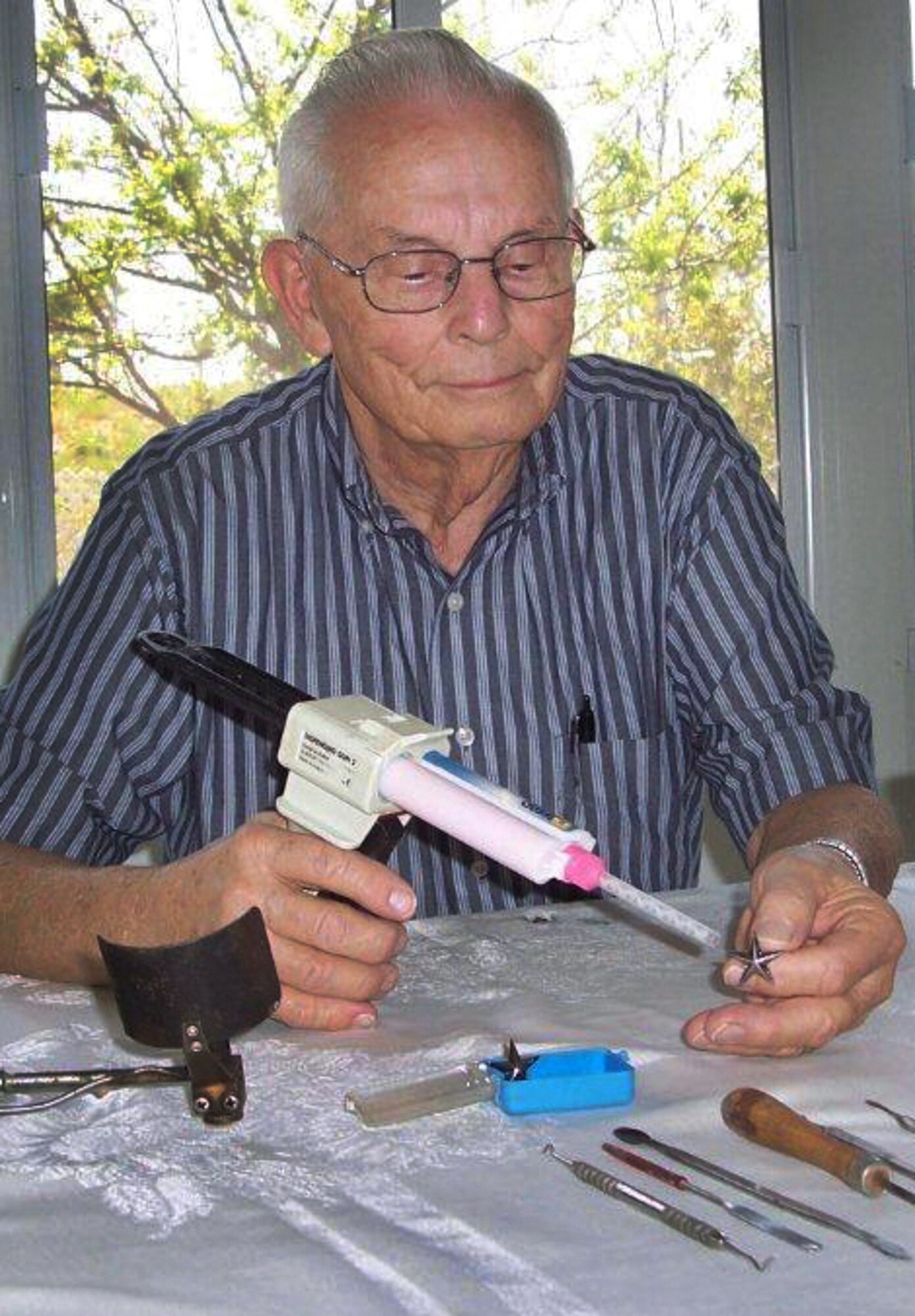 Delmar Chase crafts brigadier general's stars June 15, 2010, at his home in Calimesa, Calif. Mr. Chase is the father of Brig. Gen. Sandra Finan. A retired dental technician, Mr. Chase has hand made an insignia for each rank for the general since she was a major. General Finan is the Air Force Global Strike Command Inspector General. (Photo courtesy of the Chase family) 