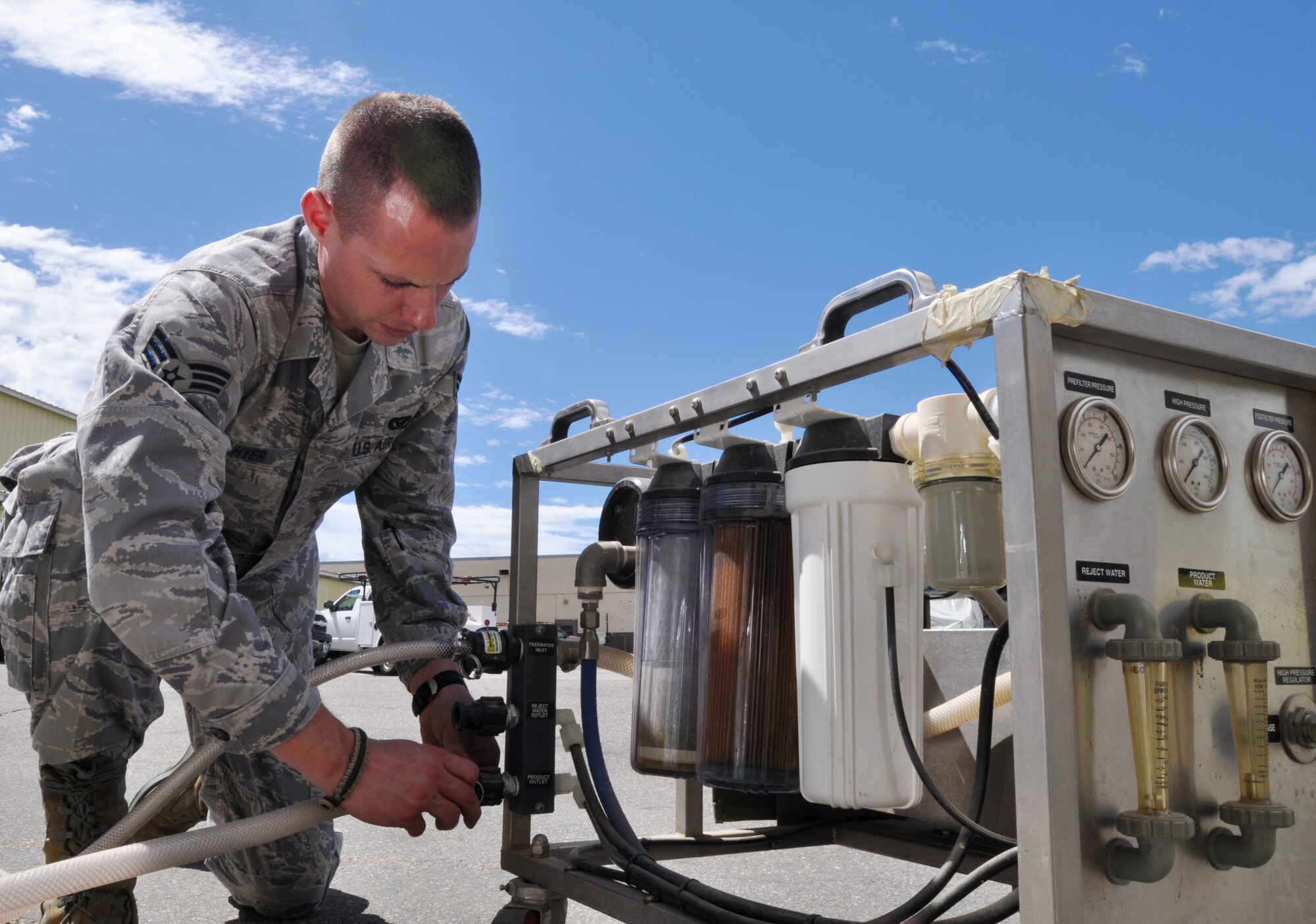 Senior Airman Randy Hyer, utilities systems journeyman in the 419th Civil Engineer Squadron, connects hoses to a portable reverse osmosis water perfection unit that can turn undrinkable water to drinkable through a series of filters. (U.S. Air Force photo/Staff Sgt. Kyle Brasier)