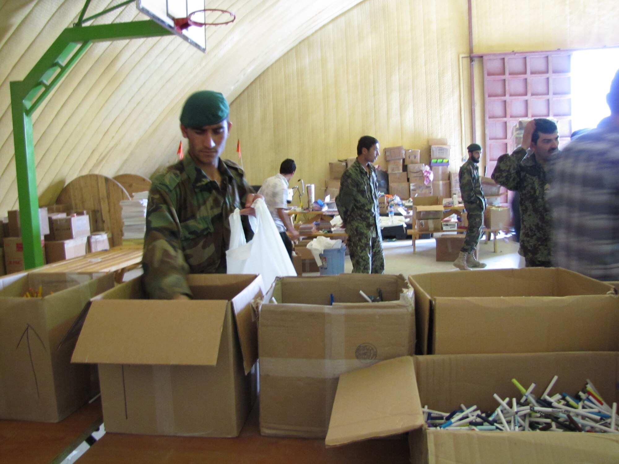 A member of the Afghan National Army Air Forcehelps build bags of schools supplies to deliver to local schools in the city of Kabul May 5, 2010.  (U.S. Air Force photo by Capt. Rob Leese/RELEASED).                       