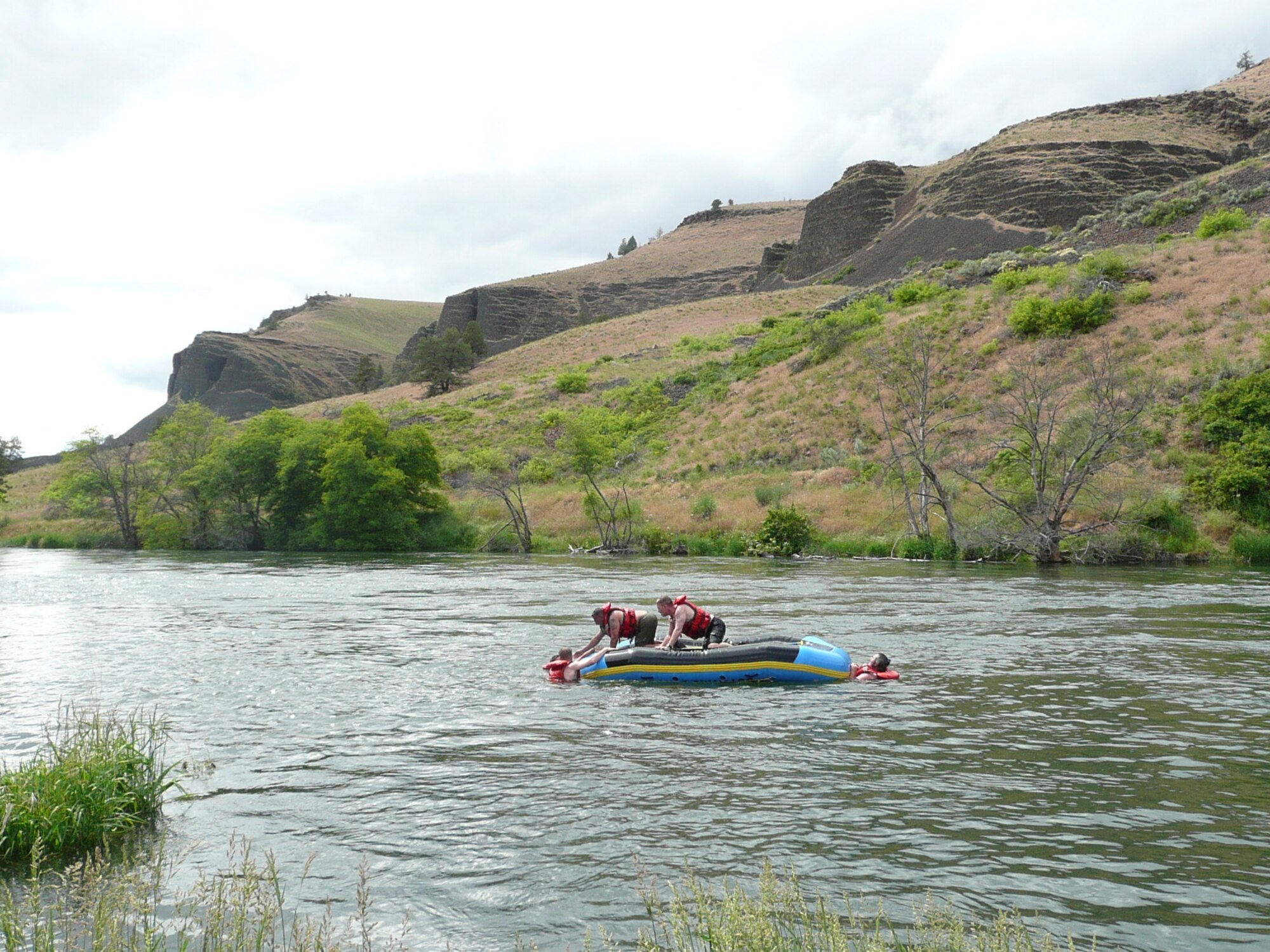 Sgt. Maj. Of the Marine Corps James M. Betancourt, MCI West, Camp Pendleton and Petty Officer 2nd Class Scott A. Fessenden, Marex Boat Det. 813, Groton Submarine Base assist their teammates in boarding a top-sized raft.  Students on the Outward Bound white water rafting trip conducted exercises on regaining control of a raft in the possible event of being capsized in the rapids.  The course took place along the Lower Deschutes River, OR. Students attended a free Outward Bound whitewater rafting expedition, June 6 to 10 (U.S. Air Force photo/Capt. Rebecca A. Garcia).