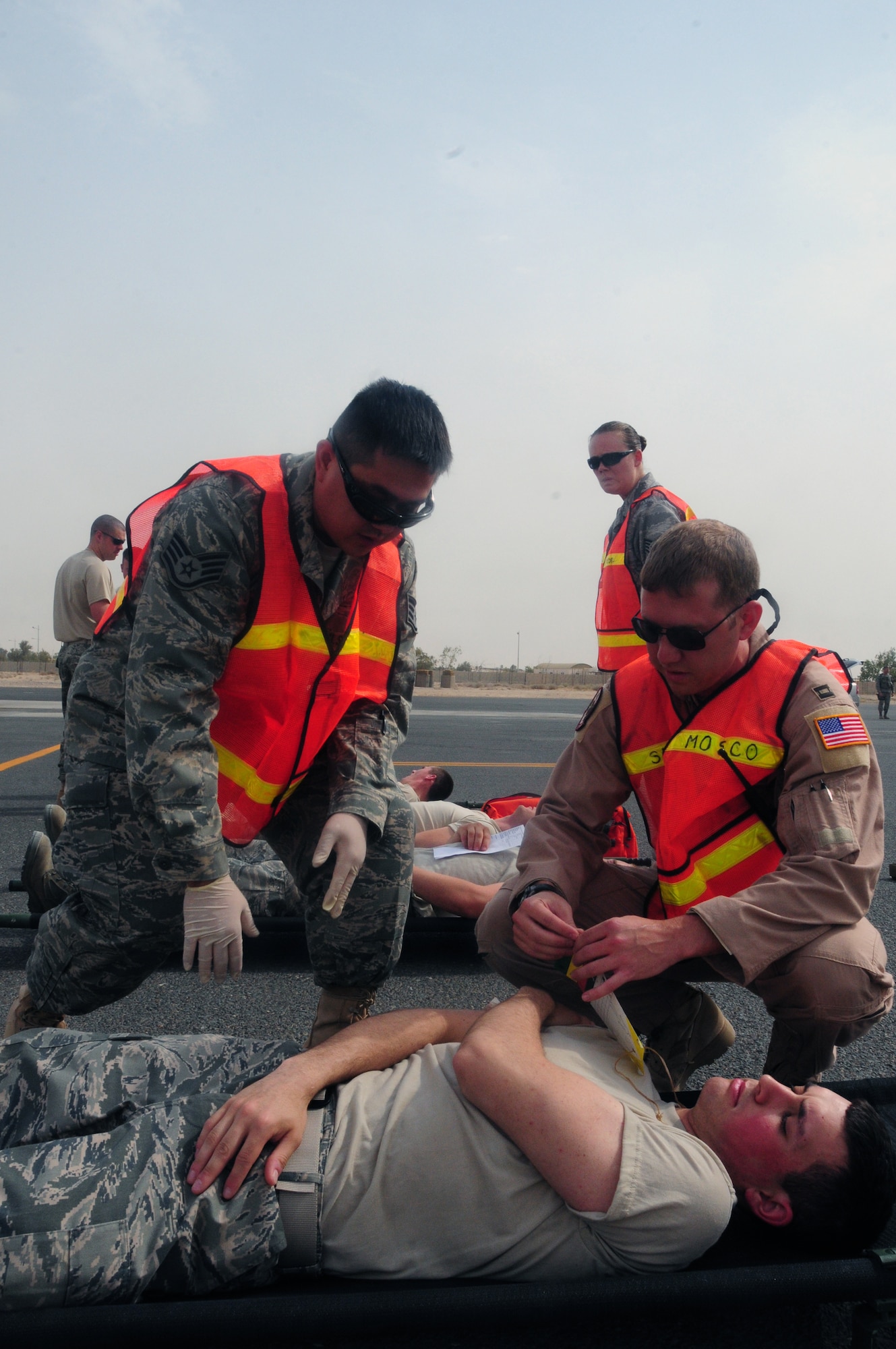 SOUTHWEST ASIA - From left, U.S. Air Force Staff Sgt. Ed Aquino, 737th Expeditionary Airlift Squadron independent duty medical technician, and Capt. Kyle Jarnagin, 386th Expeditionary Operations Support Squadron flight surgeon, asses the condition of a mock patient waiting to be transported to the Contingency Aeromedical Staging Facility here June 18, 2010 during a Major Accident Response Exercise at an undisclosed air base. U.S. Air Force Academy cadets acted as patients aboard the aircraft in the exercise used to test the wing's emergency response abilities. The cadets are visiting the 386th Air Expeditionary Wing this month to experience military life downrange. (U.S. Air Force photo by Staff Sgt. Lakisha A. Croley/Released)