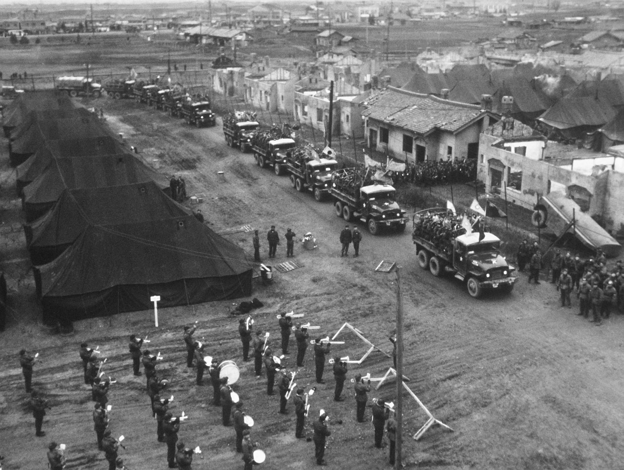 A convoy takes Chinese and North Korean POWs to Inchon, Korea, on their journey to freedom during Operation Comeback. A military band welcomes them. (U.S. Air Force photo)