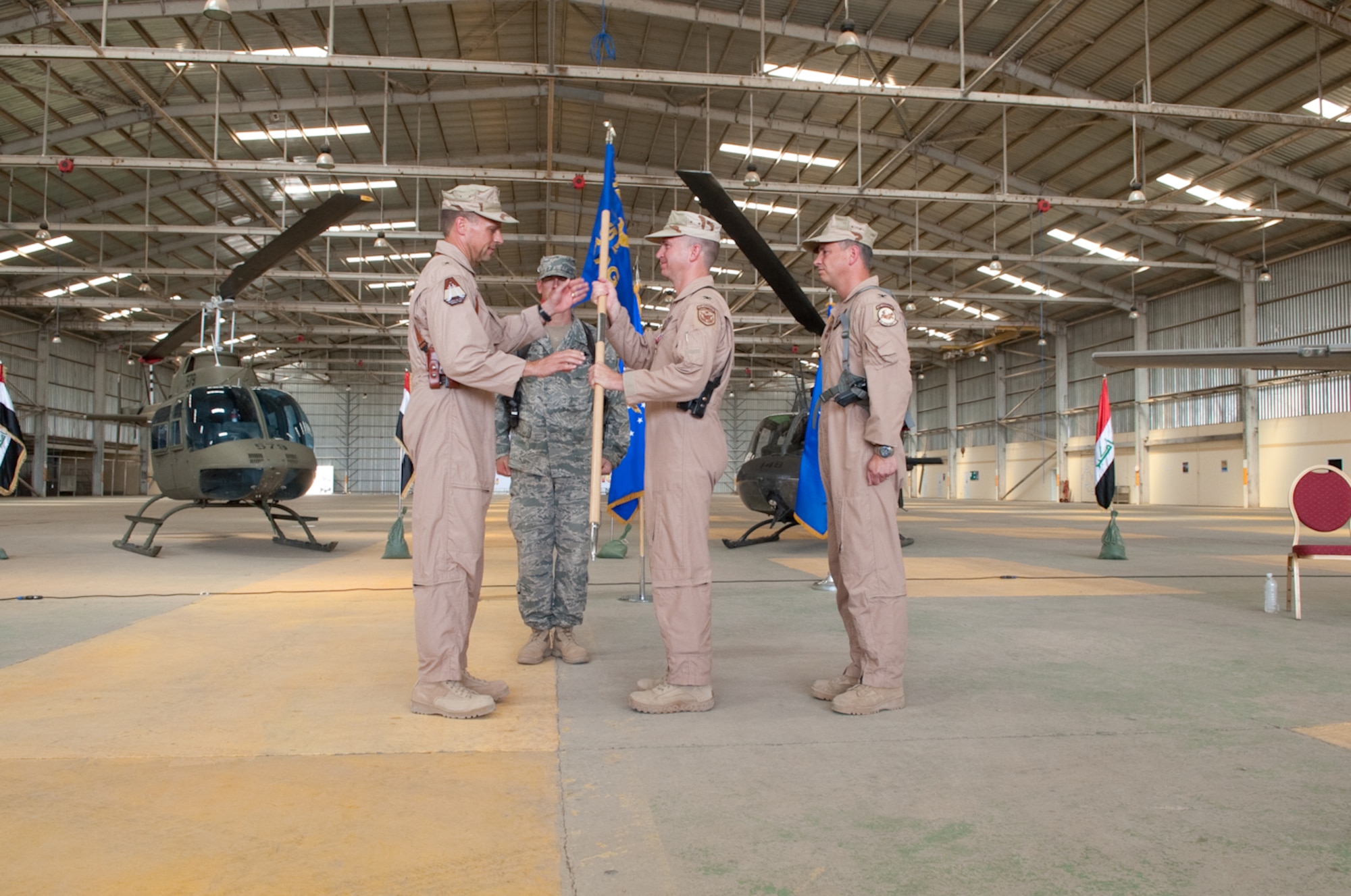 Col. Christopher Pehrson, commander, 321st Air Expeditionary Advisory Group relinquishes his command and passes  the guidon to Brig. Gen. Scott Hanson, commander, 321st Air Expeditionary Wing, and director, Iraqi Training Advisory Mission-Air Force, the presiding officer over the ceremony at Kirkuk Regional Air Base, Iraq, June 14, 2010. The group's mission is to advise and assist the Iraqi Air Force in developing credible, professional, and enduring capabilities.