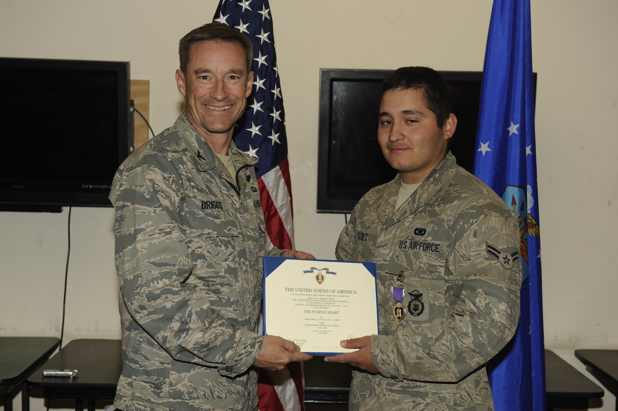 U.S. Air Force Airman 1st Class Giovanni Flores, 455th Expeditionary Security Forces Squadron, receives a Purple Heart Medal from Col. Jack Briggs, 455th Air Expeditionary Wing Commander, during a ceremony at Bagram Airfield, June 11, 2010. Airman Flores is deployed from Tinker Air Force Base, Okla., and is a Dallas, Texas native. (U.S. Air Force photo by/ Master Sgt. Jeromy K. Cross) 
