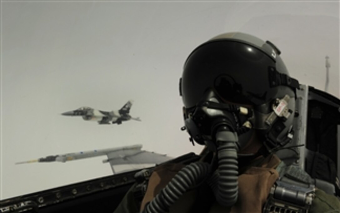 U.S. Air Force Tech. Sgt. James L. Harper Jr., of 1st Combat Camera Squadron out of Joint Base Charleston, S.C., takes a self-portrait with an F-16 Aggressor aircraft from the 18th Aggressor Squadron out of Eielson Air Force Base, Alaska, in the background during a sortie at Eielson in support of training exercise Red Flag-Alaska 10-3 on June 15, 2010.  