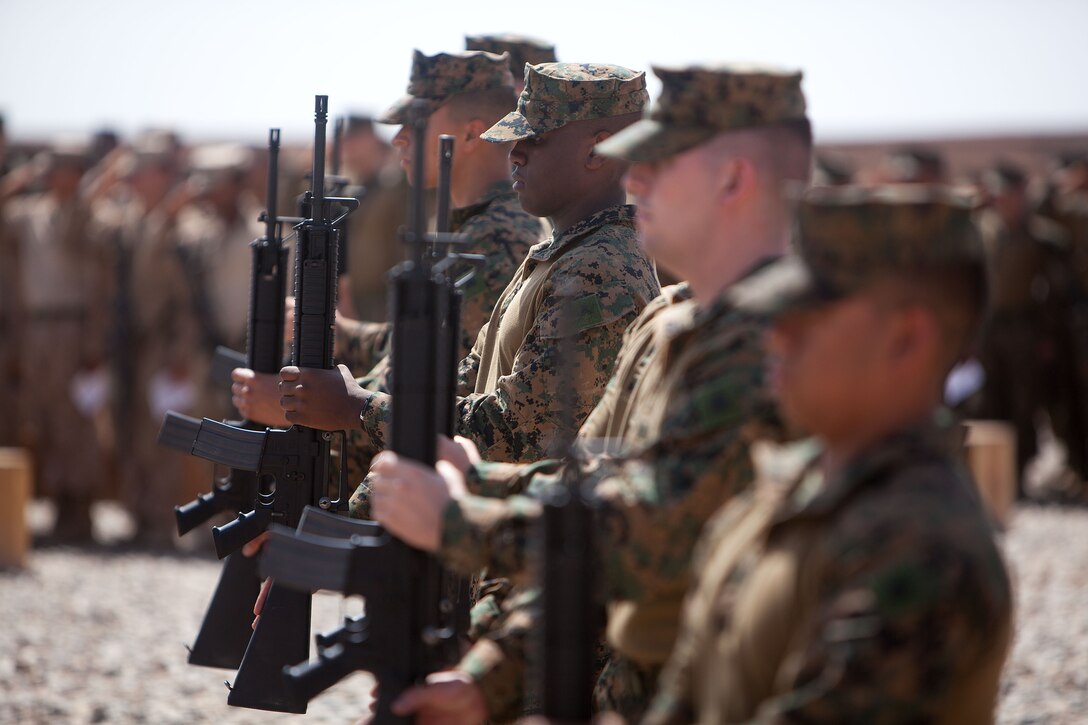 A firing detail of Marines with Weapons Company, 2nd Battalion, 9th Marine Regiment, salute as taps is played during a memorial service in honor of Lance Cpl. Abraham Tarwoe, a dog handler and mortarman who served with Weapons Company, 2nd Bn., 9th Marines, here, April 22, 2012. Tarwoe was killed in action during a dismounted patrol in support of combat operations in Helmand province’s Marjah district, April 12. Tarwoe’s fellow Marines remember him for his contagious laughter and smile, and his unfaltering courage on the battlefield.