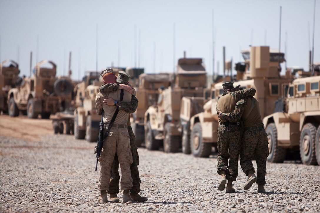 U.S. Marines with Weapons Company, 2nd Battalion, 9th Marine Regiment, comfort each other after paying their respects to a battlefield cross in honor of Lance Cpl. Abraham Tarwoe, a dog handler and mortarman who served with Weapons Company, 2nd Bn., 9th Marines, after a memorial service here, April 22, 2012. Tarwoe was killed in action during a dismounted patrol in support of combat operations in Helmand province’s Marjah district, April 12. Tarwoe’s fellow Marines remember him for his contagious laughter and smile, and his unfaltering courage in the battlefield.