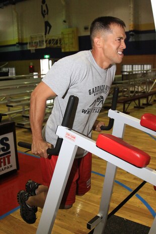 Anthony Baker, Marine Wing Support Squadron 171 chaplain, performs a maximun set of dips during the Commander’s Cup Endurance Challenge at the IronWorks Gym here June 18.