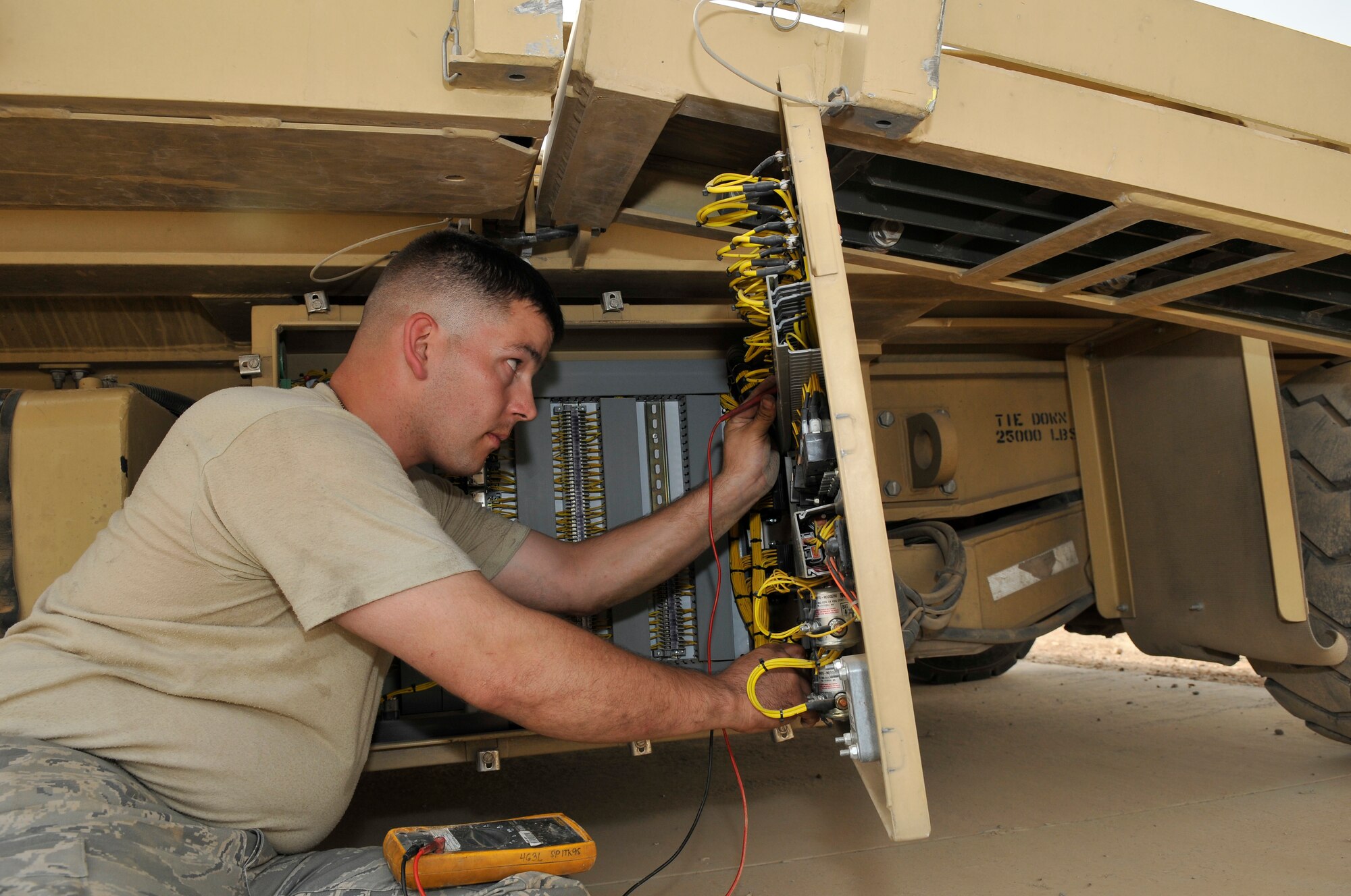 Staff Sgt. Patrick Burris, 332nd Expeditionary Logistics Readiness Squadron Material Handling Equipment Shop vehicle maintenance technician, checks for continuity in a main power panel June 18, 2010, Joint Base Balad, Iraq. The 25K Halverson Cargo Loader is a vehicle used to load C-17 Globe Master III and other large aircraft. Sergeant Burris is deployed from Aviano Air Base, Italy.  (U.S. Air Force photo\Staff Sgt. Phillip Butterfield)
