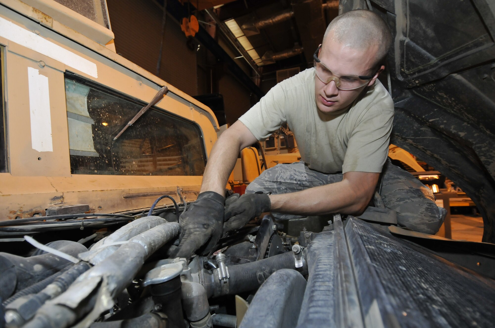 Staff Sgt. Chris Cratty, 332nd Expeditionary Logistics Readiness Squadron Force Protection Shop vehicle maintenance technician, removes an engine coolant temperature sensor to troubleshoot an over-temperature problem on a Humvee June 16, 2010, Joint Base Balad, Iraq. The FPS maintains all force protection vehicles helping to ensure base security. Sergeant Cratty is deployed from Ramstein Air Base, Germany. (U.S. Air Force photo\Staff Sgt. Phillip Butterfield)