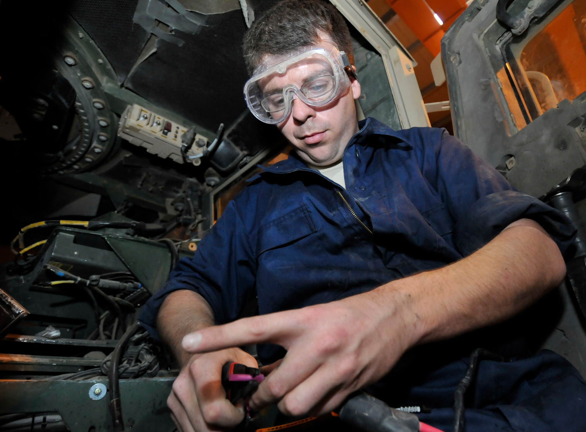 Staff Sgt. Christopher Wall, 332nd Expeditionary Logistics Readiness Squadron Force Protection Shop vehicle maintenance technician, crimps a splice for a battery wire harness June 16, 2010, Joint Base Balad, Iraq. The FPS maintains all force protection vehicles helping to ensure base security. Sergeant Wall is deployed from Barksdale Air Force Base, La. (U.S. Air Force photo\Staff Sgt. Phillip Butterfield)