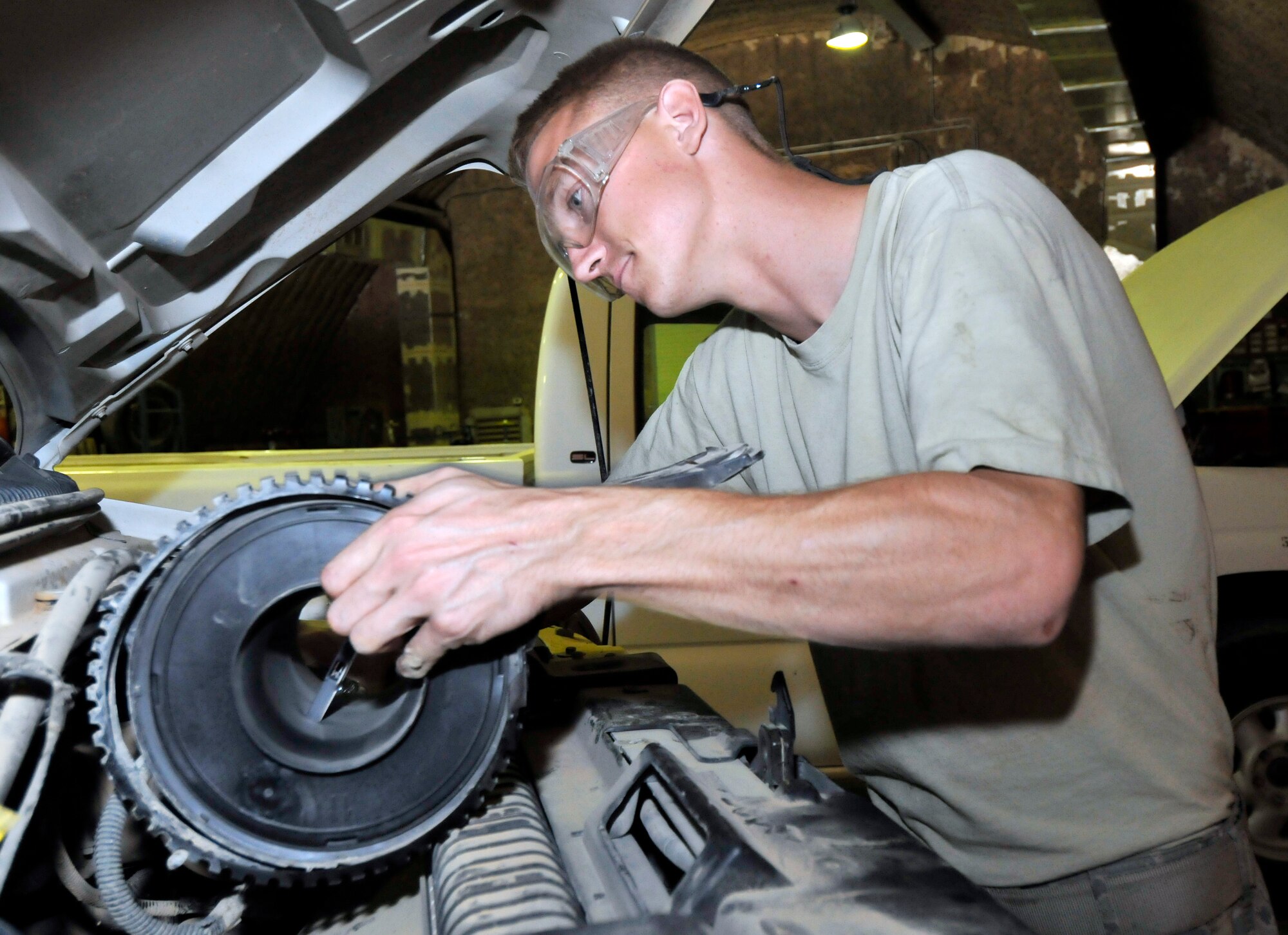 Staff Sgt. Ryton Hitzel, 332nd Expeditionary Logistics Readiness Squadron Customer Service Shop vehicle maintenance technician, removes a mass air filter assembly June 16, 2010, Joint Base Balad, Iraq. The mass air filter assembly cleans the air before being introduced to the rest of the vehicle. Sergeant Hitzel is deployed from Ellsworth Air Force Base, S.D. (U.S. Air Force photo\Staff Sgt. Phillip Butterfield)