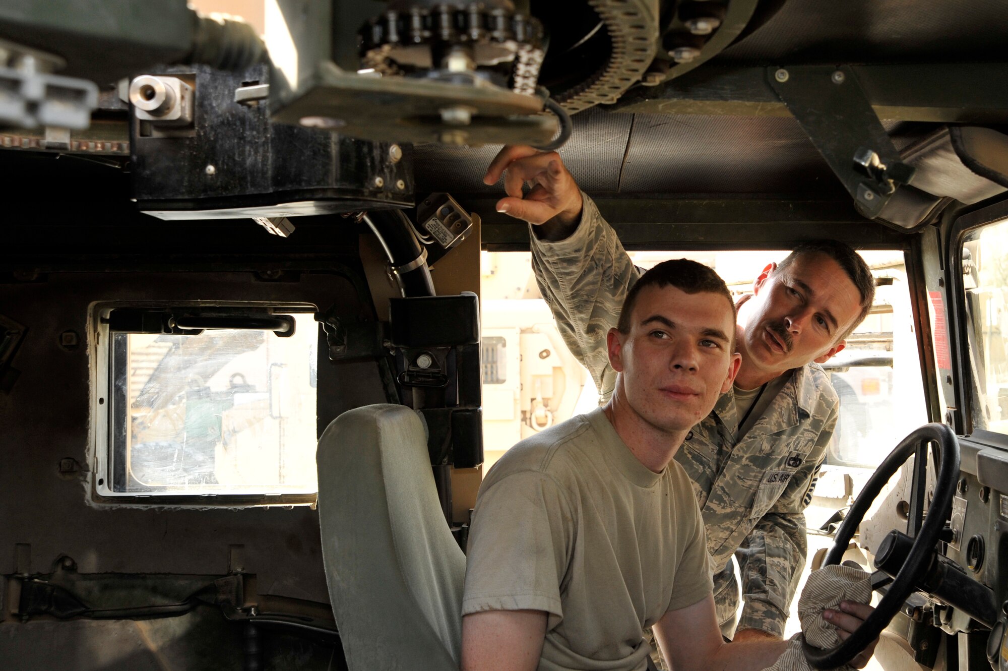 Senior Master Sgt. CJ Slifko, 447th Expeditionary Logistics Readiness Squadron, vehicle fleet manager, deployed from McConnell Air Force Base, Kan., Inspects the turret chain with his son, Airman 1st Class Ryan Slifko, 447th ELRS, vehicle mechanic, deployed from Whiteman AFB, Mo. They performed a limited technical inspection on an excess Humvee to determine if its in a good enough condition to be sent to Afghanistan or sent to a depot to be rebuilt, June 19, 2010, at Sather Air Base, Iraq. Airman Slifko, from Derby, Kan., joined the Air Force and went into the same career field, and deployed to the same unit as his father. (U.S. Air Force photo by Senior Airman Perry Aston/Released)